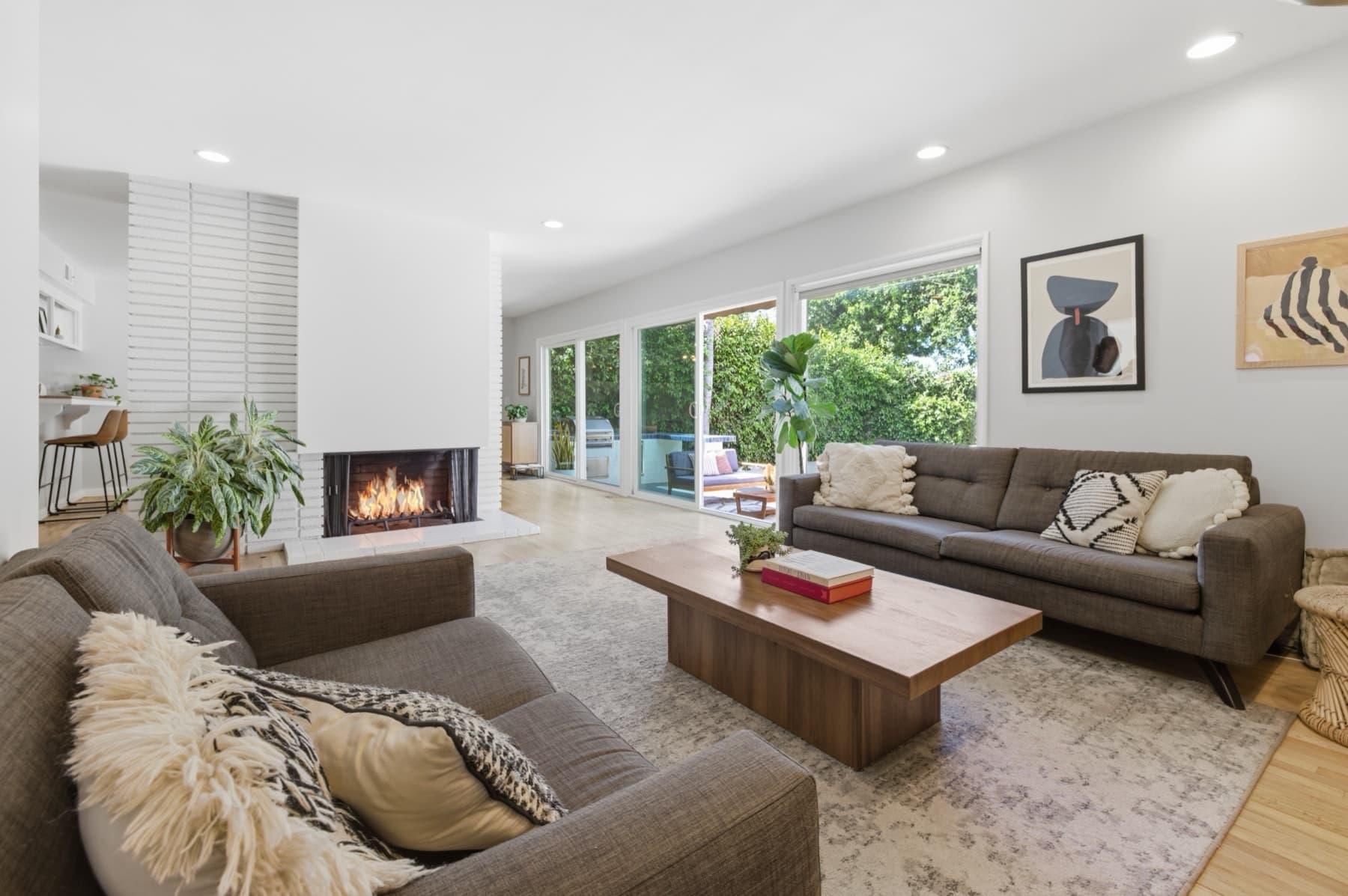 Bright living room with a fireplace and windows opening to a garden