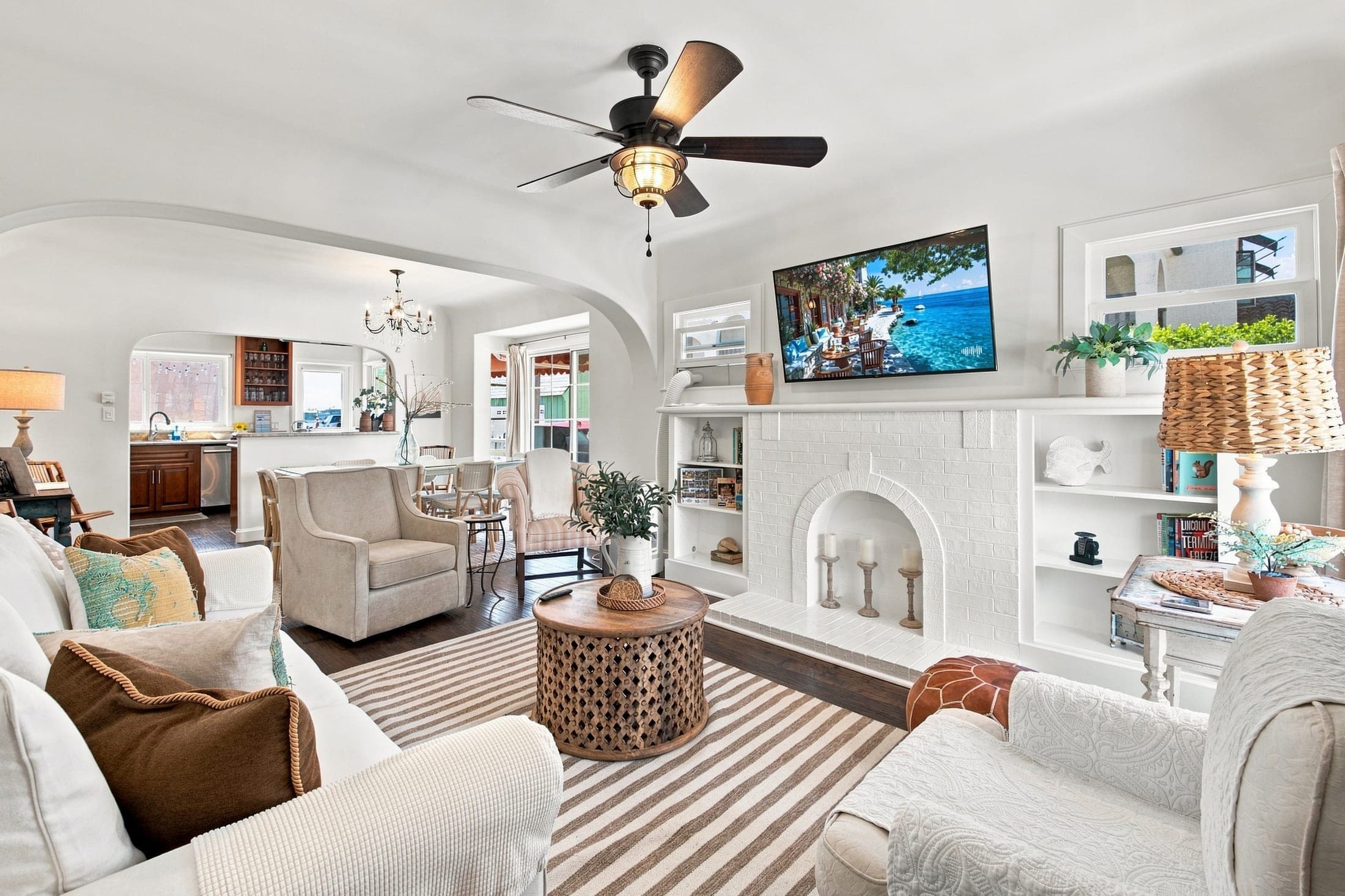 Claremont vacation rental living room with white seating and a fireplace